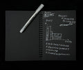 Black notebook and white pen